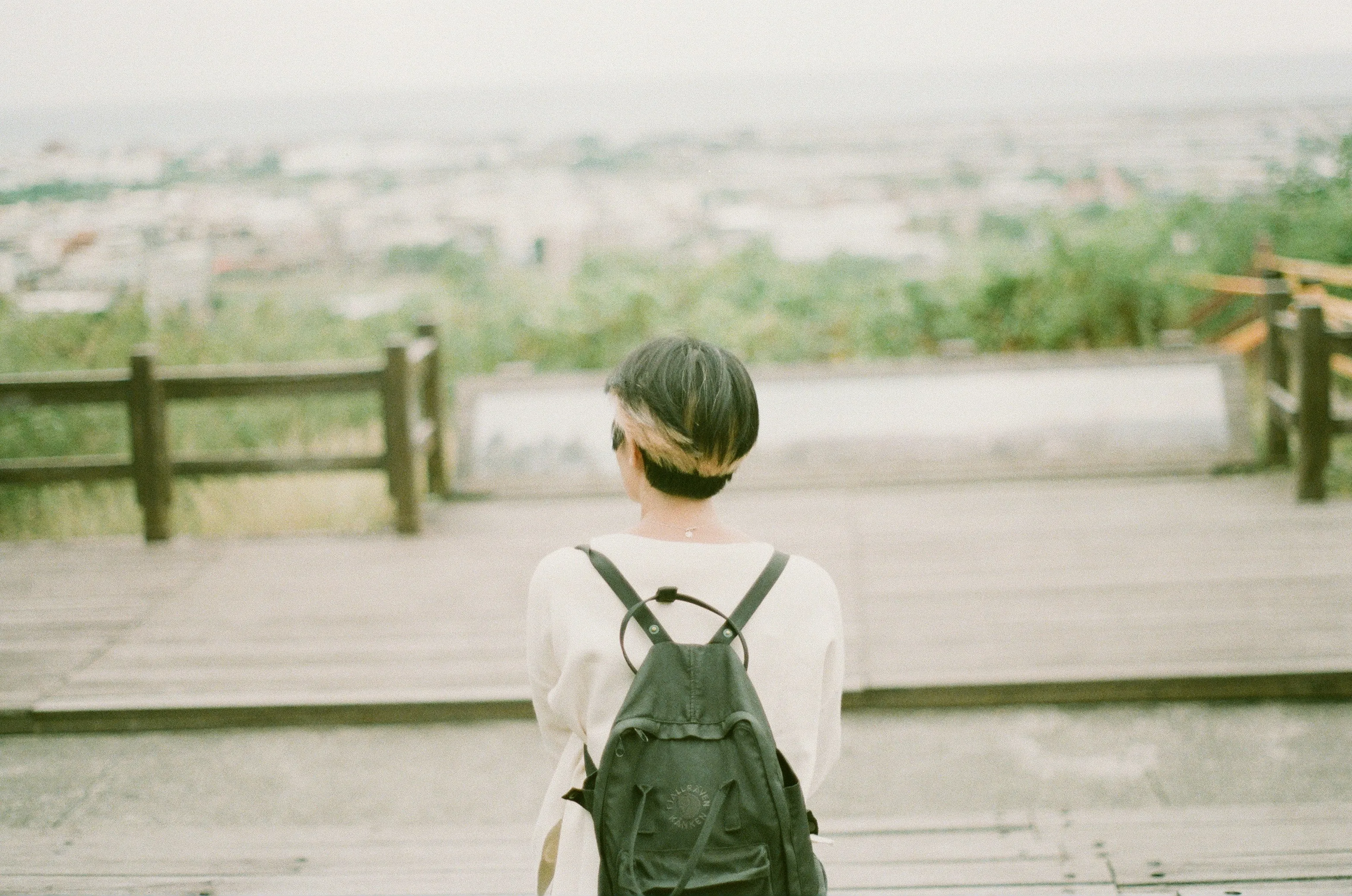 A woman with a backpack standing on a wooden platform